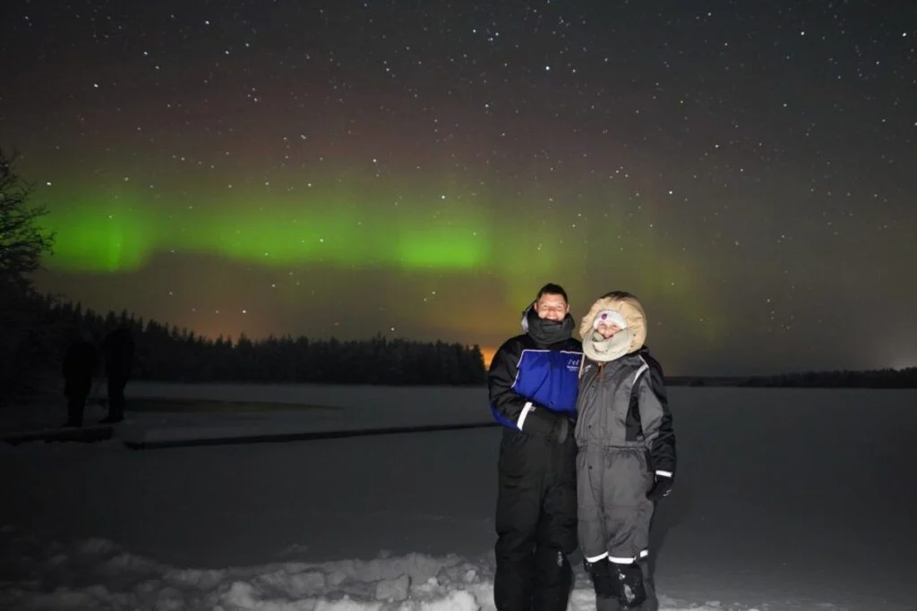Revontulet jäätyneen järven yllä Rovaniemen lähellä