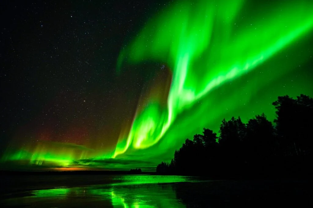 Autumn Ruska colours and early-season aurora over open water near Rovaniemi, Finnish Lapland