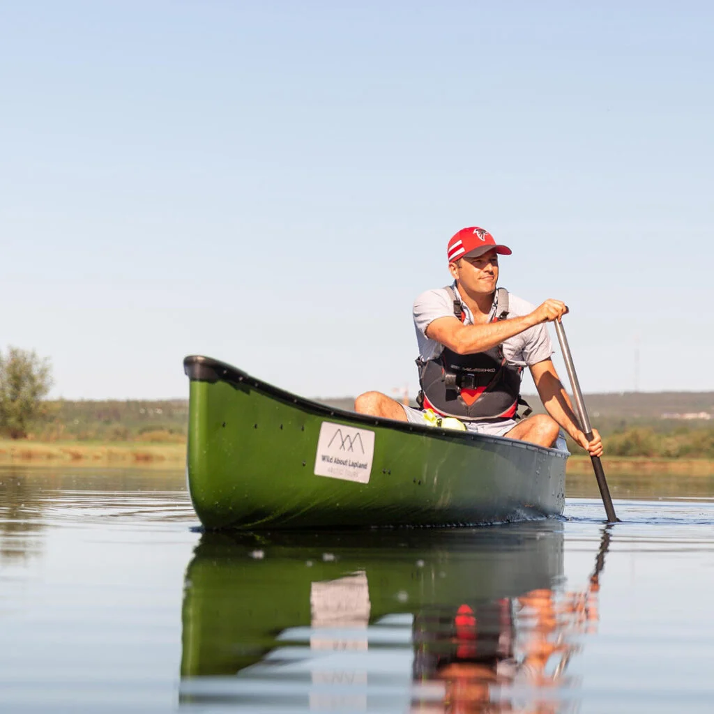 Woman canoeing on a lake during summer in Rovaniemi