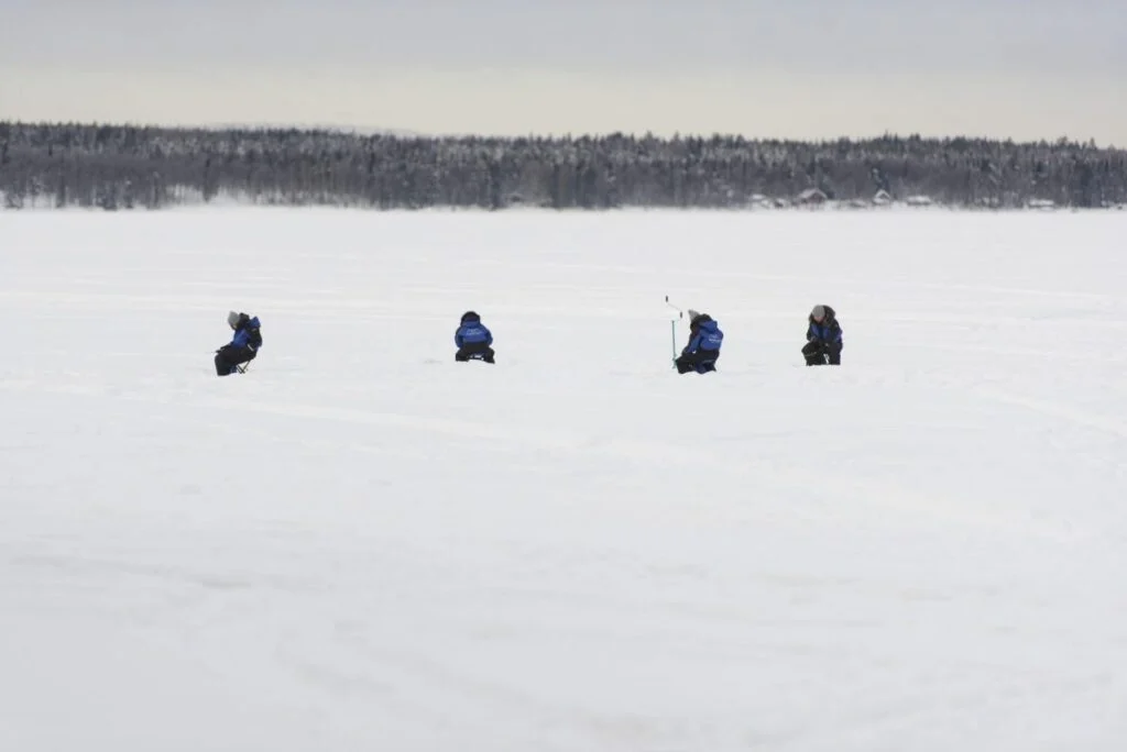 Ice fishing on a frozen lake near Rovaniemi