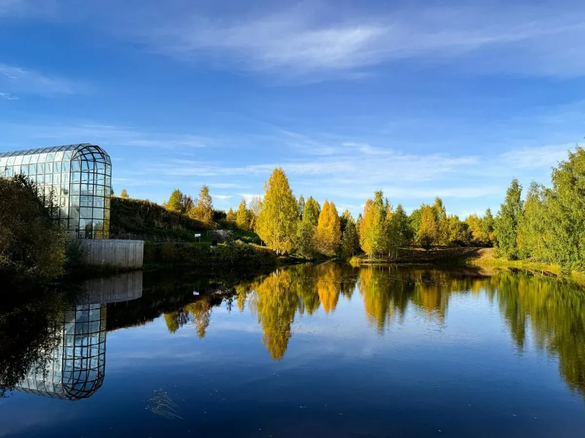 Arktikum reflected in a pond among autumn trees in Rovaniemi