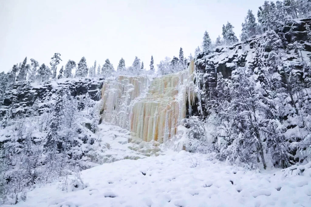 Towering blue frozen waterfall in Korouoma Canyon near Rovaniemi, winter ice formations
